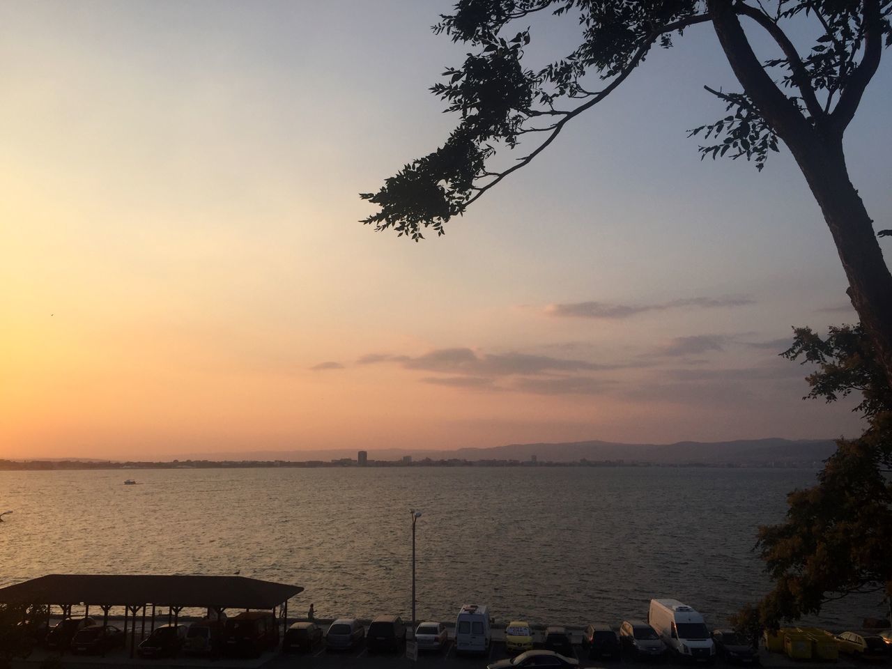 sunset, tree, water, transportation, sky, tranquil scene, nautical vessel, sea, scenics, mode of transport, tranquility, orange color, nature, tourism, vacations, outdoors, beauty in nature, non-urban scene, atmosphere, cloud - sky, no people, dramatic sky, harbor, atmospheric mood