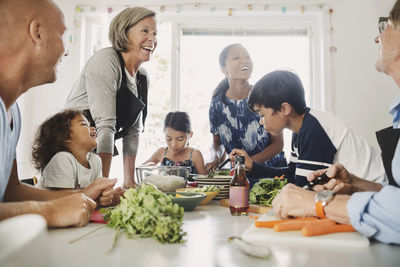 Happy multi-ethnic family preparing asian food at kitchen