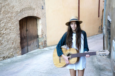 Full length of young woman holding guitar