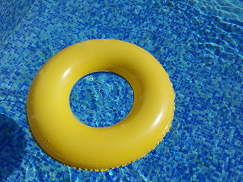 High angle view of yellow inflatable ring in swimming pool