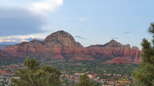 Rock formations on landscape against cloudy sky