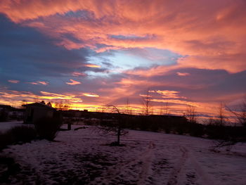 Scenic view of snow covered landscape at sunset