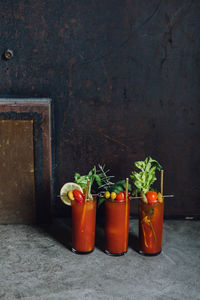 Bloody mary tomato brunch cocktail drink with celery, lemon, rosemary, pickles, olives, gold straw