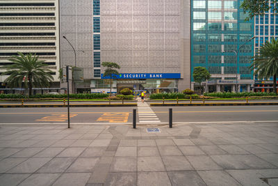 Person walking on sidewalk by modern building in city