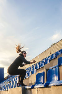 Full length of woman exercising in stadium