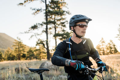 Male mountain biker in meadow at sunrise