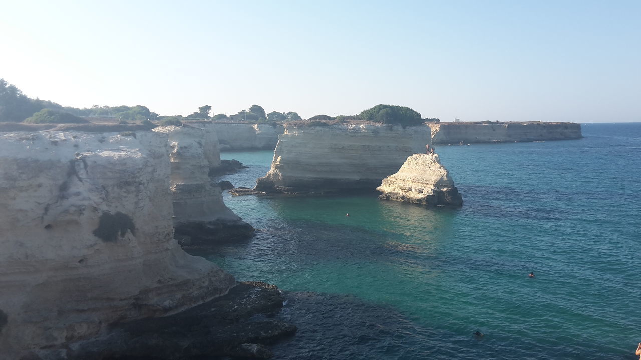 ROCKS ON SEA AGAINST CLEAR SKY