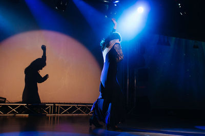 Full length of silhouette man standing at music concert