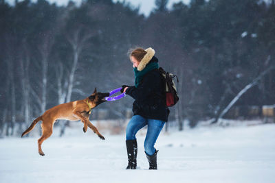 Full length of a dog on snow covered field
