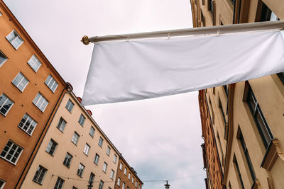 Horizontal white empty banner on clothes shop front against old buildings in city