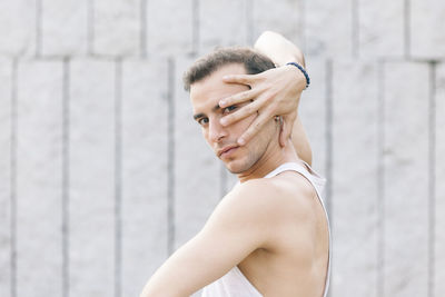 Portrait of young man dancing against wall