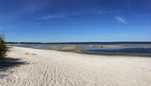 Scenic view of beach against blue sky