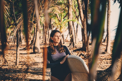 Mature woman carrying surfboard at beach