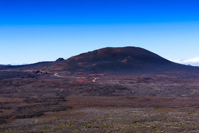 Scenic view of desert against clear blue sky
