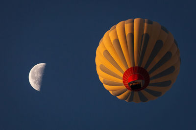 Low angle view of hot air balloon against clear blue sky