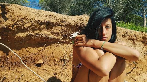 Portrait of young woman sitting at beach