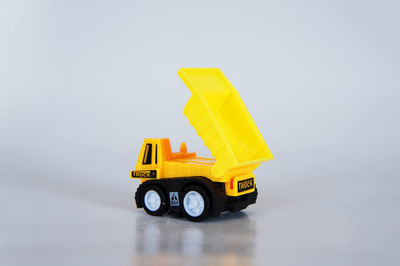 Close-up of yellow toy car over white background