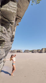 Full length of woman on beach against clear sky