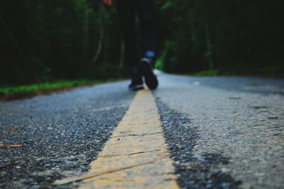 Low section of man walking on road