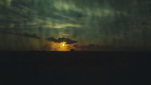 Silhouette landscape against sky at night