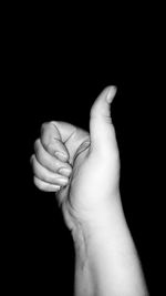 Close-up of human hand against black background