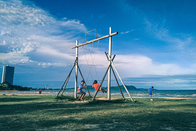 People playing on field against sky