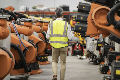 Engineer in reflective clothing walking in factory