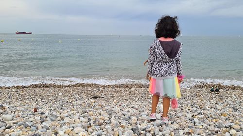 Rear view of woman standing on beach