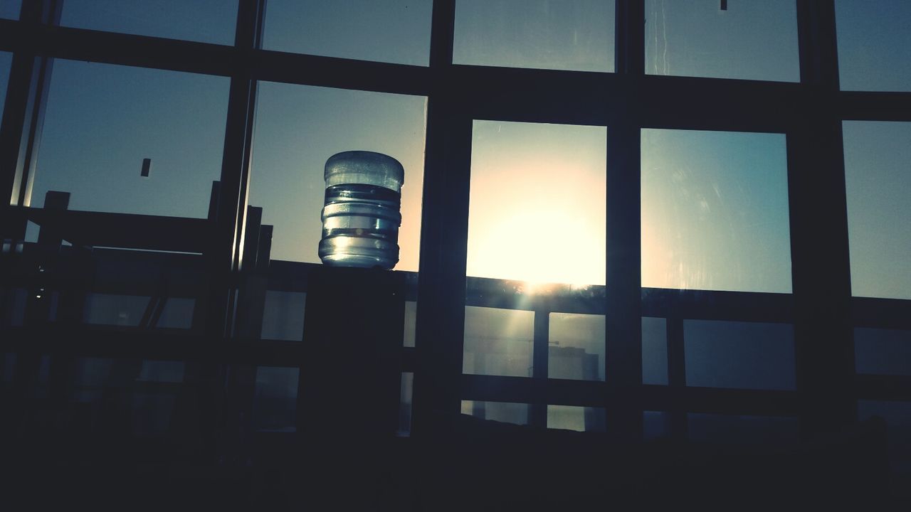 window, sun, glass - material, sunset, built structure, architecture, sky, indoors, transparent, sunlight, low angle view, silhouette, building exterior, sunbeam, reflection, no people, lens flare, glass, safety, nature