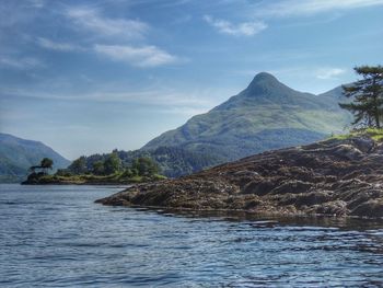 Scenic view of sea and mountains against sky