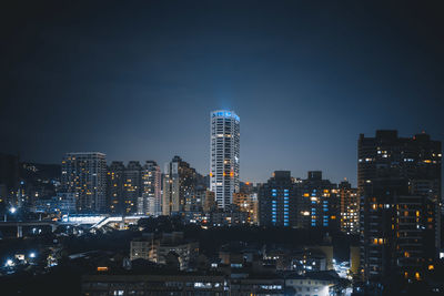 Illuminated buildings against sky at night