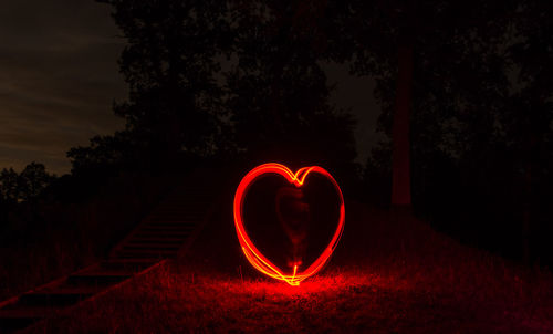 Heart shape on illuminated tree against sky at night