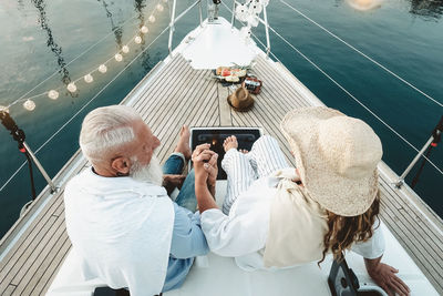 High angle view of couple holding hands while sitting in boat