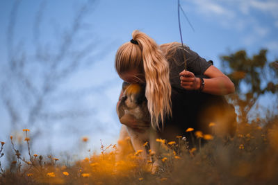 Woman with dog against sky