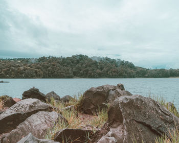 Rocks by sea against sky