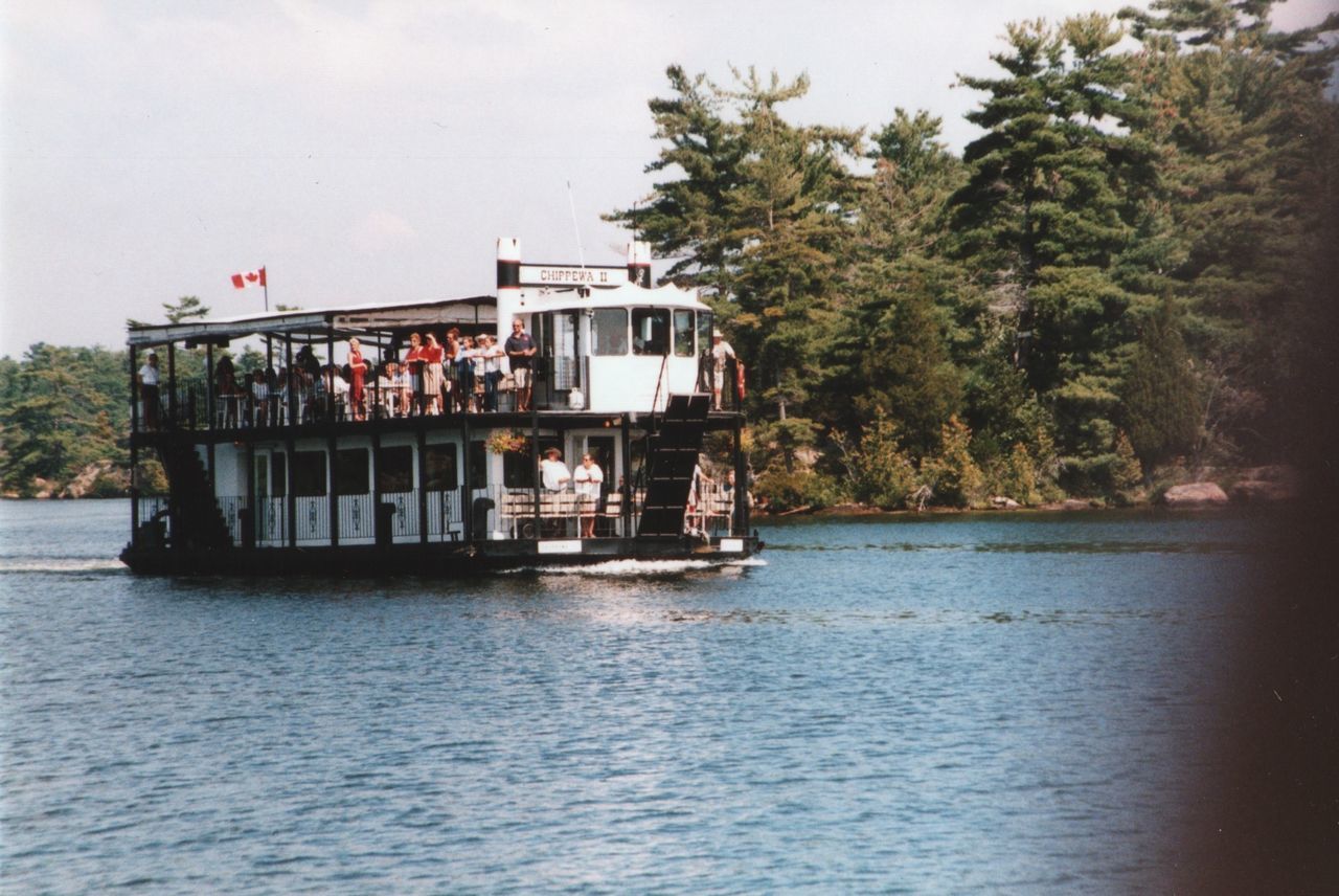 BOAT SAILING ON RIVER AGAINST TREES