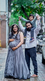 Portrait of smiling woman with her family. husband, wife and son. expecting mother 