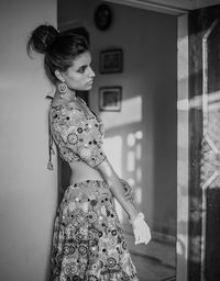 Woman in traditional clothing standing at home