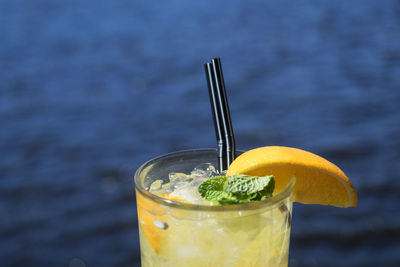 Close-up of lemonade in glasses against sea