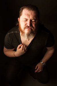 Portrait of man against black background