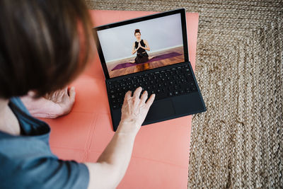 High angle view of woman using laptop at home