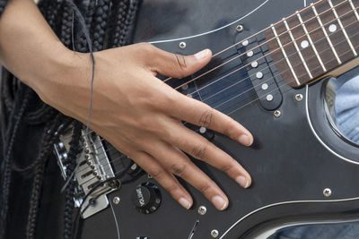 Midsection of woman playing guitar