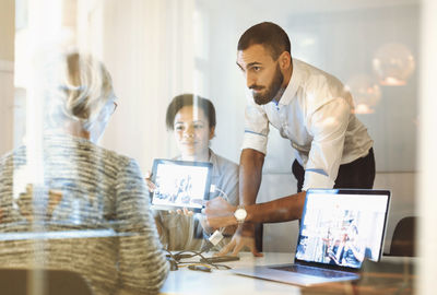 Business people giving presentation to colleague in office