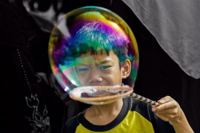 Close-up portrait of a boy making bubble