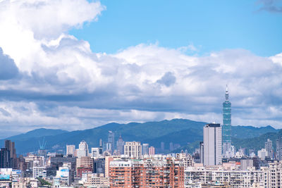 Buildings in city against cloudy sky