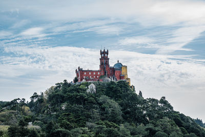 National pena palace in sintra, portugal. view of hill cover with trees with palace on top