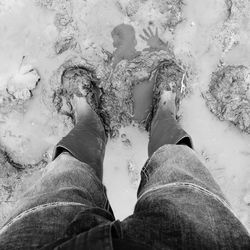 Low section of man standing in mud