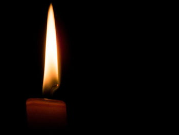 Close-up of burning candle in darkroom