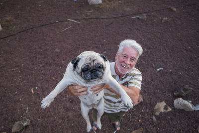 Senior man holding pug