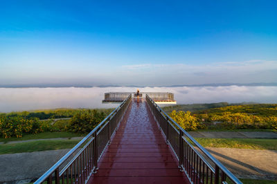 Footbridge over water against sky